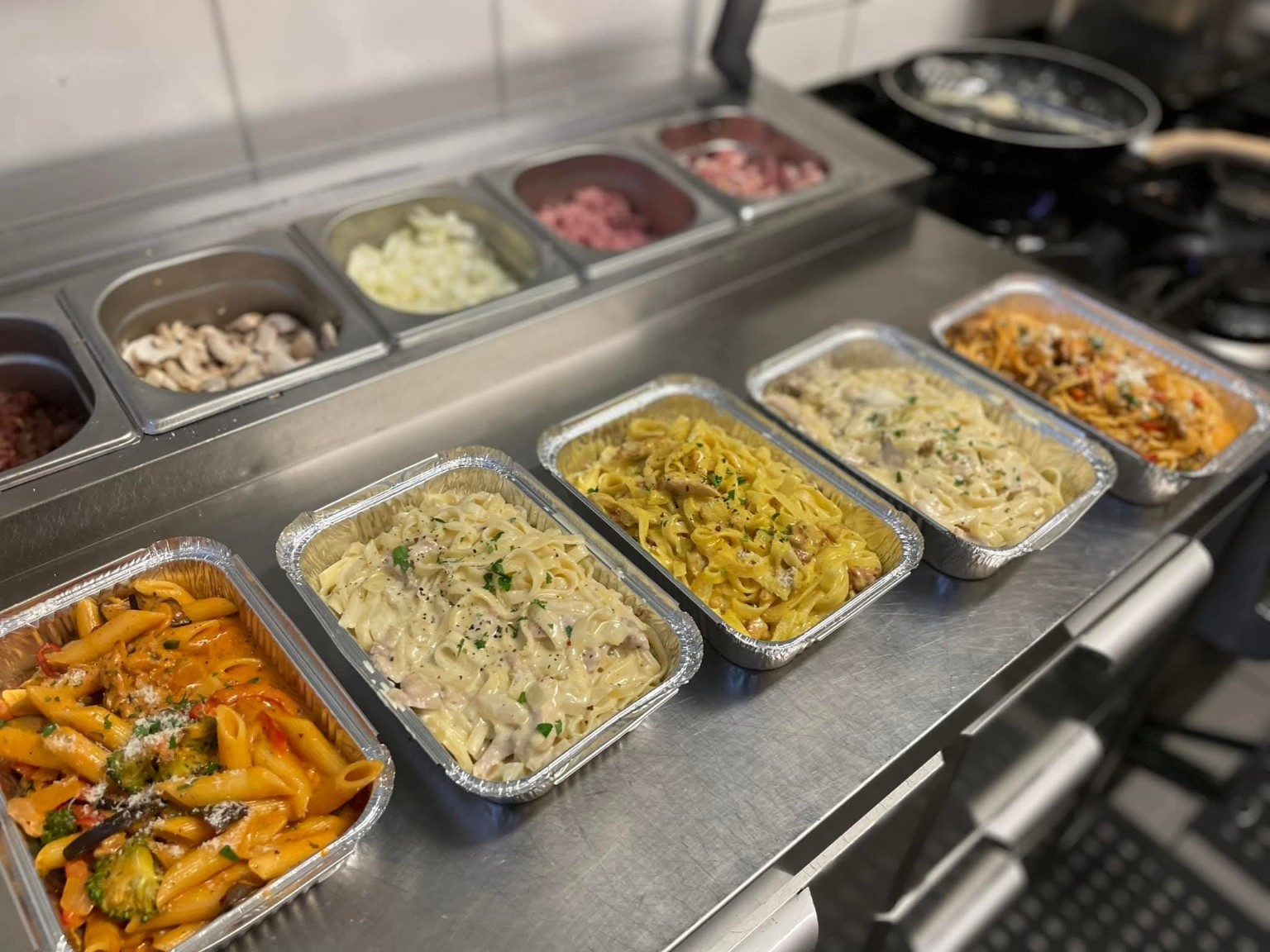 Et utvalg pastaretter pakket i former på kjøkkenbenken
